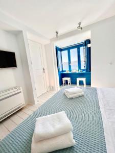 a bedroom with a large bed with two white towels at mills suites mykonos in Mýkonos City