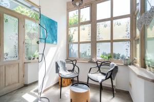 ソポトにあるBy The Sea Sopot Apartamentの窓付きの客室で、椅子2脚とランプが備わります。