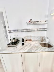 a white kitchen with a counter top with a sink at mills suites mykonos in Mikonos