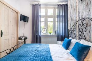 ソポトにあるBy The Sea Sopot Apartamentのベッドルーム(青と白のベッド1台、窓付)