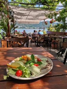 een bord eten op een houten tafel bij Miryana Guest House in Ohrid