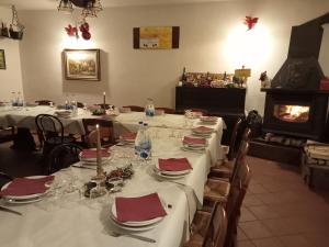un comedor con mesas blancas y servilletas rojas en AGRITURISMO LA FATTORIA, en Ranzo-Borgo