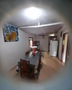 - un salon avec une table et un réfrigérateur dans l'établissement Encanto da Montanha Hospedagem, à Príncipe