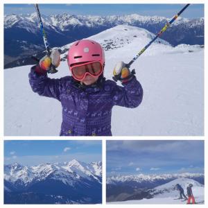 a child holding ski poles on top of a mountain at Haus Hotz in Landeck