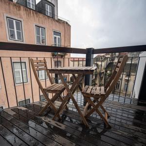 une table en bois et deux chaises assises sur un balcon dans l'établissement Correio Velho Suites, à Lisbonne 47 autres photos