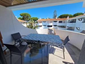 a patio with a table and chairs on a balcony at VILAMOURA APARTMENT NEAR MARINA AND BEACHES in Quarteira