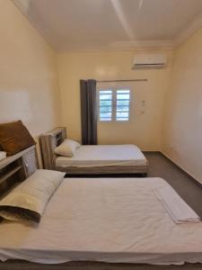 1 dormitorio con 2 camas y ventana en Residence wolf and gang, en Nouakchott