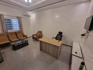 sala de estar con sillas, mesa y TV en Residence wolf and gang, en Nouakchott