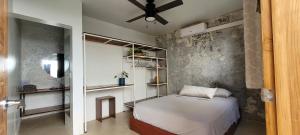 1 dormitorio con 1 cama y ventilador de techo en The Stone Elephant - A place to relax in town with Hot Water and a Pool en San Juan del Sur
