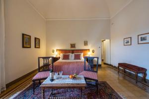 a bedroom with a bed and two chairs and a table at Castello di Sovicille - Residenza d'Epoca in Sovicille