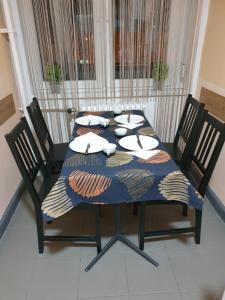 a dining room table with chairs and a blue table cloth at Central Apartman in Salgótarján