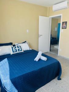 a bedroom with a blue bed with towels on it at Atena Flats in Aracaju
