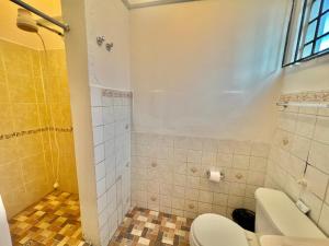 uma casa de banho com um WC e um chuveiro em Urban Hotel em Guatemala
