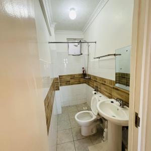 un bagno con un water e un lavandino di Residence Next Door Green Zone a Kiambu