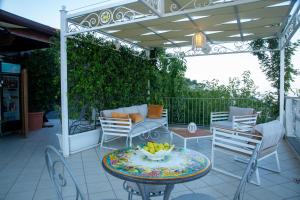 d'une terrasse avec une table, des chaises et une pergola. dans l'établissement A DREAM ISCHIA RESORT, à Ischia