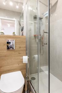 a bathroom with a toilet and a glass shower at 9th Floor Wroclaw Business Apartment by Rentujemy in Wrocław
