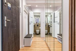 a bathroom with a toilet and a glass door at 9th Floor Wroclaw Business Apartment by Rentujemy in Wrocław