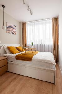 a bedroom with a large bed with a table on it at 9th Floor Wroclaw Business Apartment by Rentujemy in Wrocław