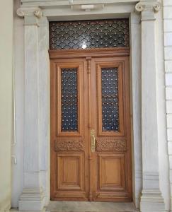 a wooden door with two windows on a building at 1906 Citygarden in Chios