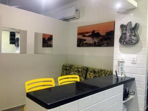 kuchnia z czarnym blatem i żółtymi krzesłami w obiekcie Gomes Freire w mieście Rio de Janeiro
