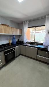 una cucina con fornelli, lavello e finestra di Sunset Villas Milagres - Casa Aguapé a São Miguel dos Milagres