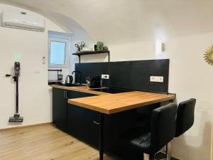 a kitchen with a counter with a wooden counter top at La Petite Suite in Sanremo