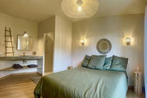 a bedroom with a large bed with blue pillows at La villa Tamaris in Buis-les-Baronnies