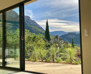 una porta a vetri aperta con vista sul giardino di La villa Tamaris a Buis-les-Baronnies