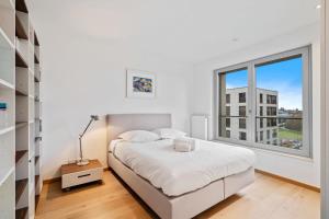 1 dormitorio con cama y ventana grande en Lux City Escape 2BR Apt with Balcony & Workspace, en Luxemburgo