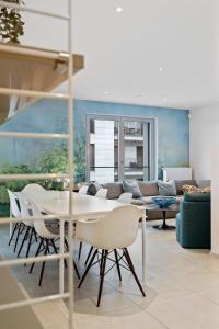 sala de estar con mesa, sillas y sofá en Lux City Escape 2BR Apt with Balcony & Workspace, en Luxemburgo