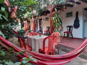 eine Terrasse mit einem Tisch, Stühlen und einer Hängematte in der Unterkunft Beija Flor Hostel in Villa de Leyva