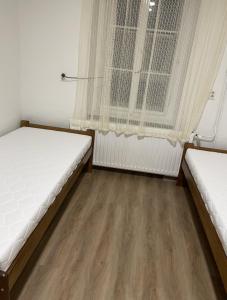 1 dormitorio con 2 camas y ventana en Breznicka 91 en Příbram