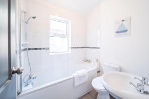 a white bathroom with a tub and a sink and a toilet at The Urban Apartment in Doncaster
