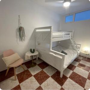 a bedroom with a white bunk bed and a chair at Villa Flores Mijas Fuengirola in Santa Fe de los Boliches