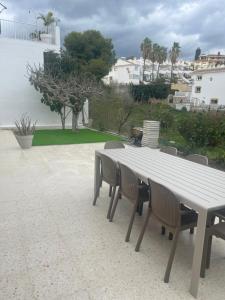 a white table and chairs with a view of the ocean at Villa Flores Mijas Fuengirola in Santa Fe de los Boliches