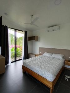 a bedroom with a bed and a large window at Toucan home in Fortuna