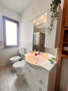 a white bathroom with a toilet and a sink at Modigliani house posizione strategica trilo in Bruino