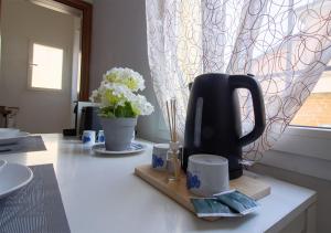 a kitchen counter with a black kettle on a cutting board at Athena Rooms - Affittacamere in Bologna