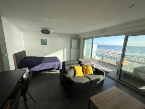 a bedroom with a couch and a bed and a balcony at Studio face mer in La Baule