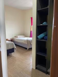 ein Schlafzimmer mit einem Bett und ein Zimmer mit einem Schrank in der Unterkunft Kicker House Turtle Room in Puerto Baquerizo Moreno