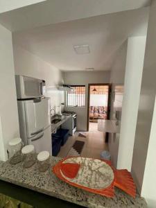 a kitchen with a counter with a pizza on it at Condomínio Costa Azul in Caraguatatuba