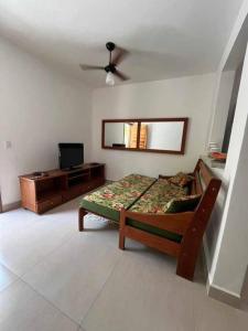 sypialnia z łóżkiem, komodą i lustrem w obiekcie Condomínio Costa Azul w mieście Caraguatatuba