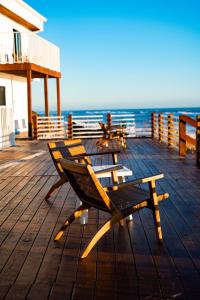 2 bancos sentados en una terraza de madera con vistas al océano en Melbourne Beach Resort en Melbourne Beach