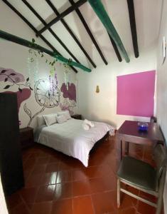 sypialnia z łóżkiem, biurkiem i stołem w obiekcie Beija Flor Hostel w mieście Villa de Leyva