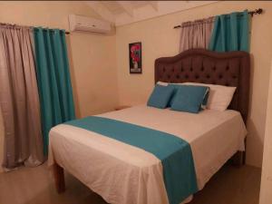 a bedroom with a large bed with green curtains at Royal Palms Luxury Villas in Ocho Rios
