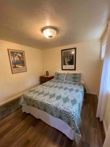 a bedroom with a bed with a green and white comforter at Zootown Bungalow in Missoula