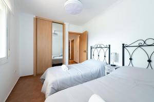 1 dormitorio con 2 camas y espejo en BrisaMar II primera línea de playa & priv parking, en Torre de Benagalbón
