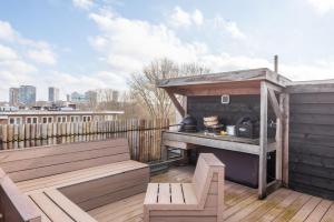 a outdoor kitchen on a deck with a bench at Bed zonder Breakfast in Amsterdam