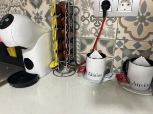 a counter with three cups with a toothbrush in them at alisios loft in Las Palmas de Gran Canaria