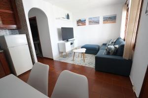 a living room with a blue couch and a tv at APARTAMENTO SON BOU in Son Bou
